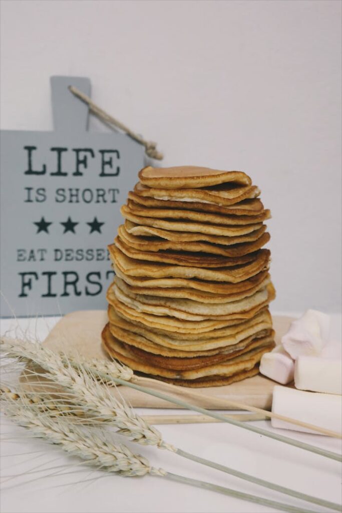 Appetizing stack of pancakes styled with wheat and marshmallows, ideal for breakfast themes.